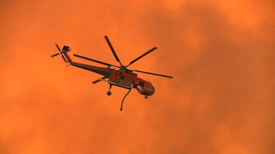 A helicopter prepares to dump water on bushfires as they approach homes located on the outskirts of the town of Bargo on December 21, 2019 in Sydney, Australia. Getty Images