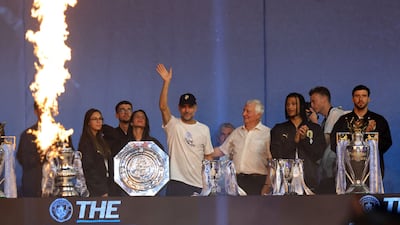 Outgoing coach Pep Guardiola waves as players pose next to all the trophies won over the length of his 10 years at the club. AFP