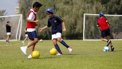 A year six PE class where the students learn football skills outdoors at Jebel Ali Primary in Dubai. Sarah Dea / The National