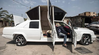 A Palestinian mechanic working on his limousine at his workshop in Gaza on April 22, 2017. Made up of five different cars, it will be rented out for use at marriage ceremonies. Mahmud Hams/AFP