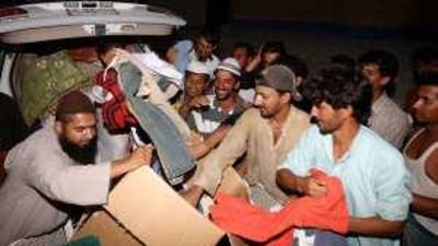 Faisal Khan, left, delivers second-hand goods to a labour camp in Ajman.