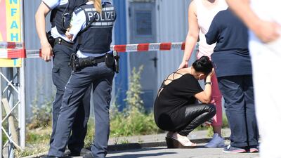 A visitor, centre, waits to be questioned by police near a discotheque in Constance, at Lake Constance, Germany. Felix Kaestle / dpa via AP