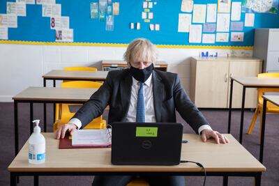 UK Prime Minister Boris Johnson sits at a desk in a school classroom in London, England. Getty