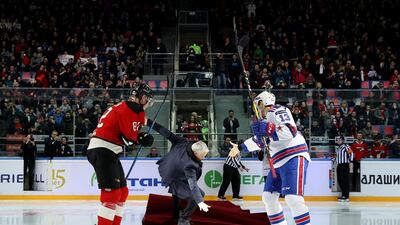 Jose Mourinho, centre, falls as he drops the puck to start a Continental hockey league match in Balashikha on Monday. AFP