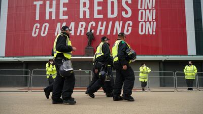 Police and security staff stand guard outside Old Trafford ahead of the Premier League match between Manchester United and Liverpool. Getty
