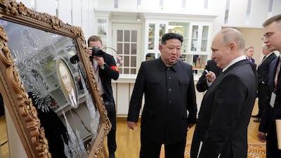 Mr Putin is presented with a gift by Mr Kim during his state visit. Reuters