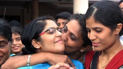 An Indian nurse, left, is greeted by a relative after arriving at Kochi airport in the southern state of Kerala on Saturday. A group of 46 Indian nurses who were trapped in an area of Iraq seized by Islamic militants were greeted by tears and cheers from relatives as they arrived home in southern India. AFP