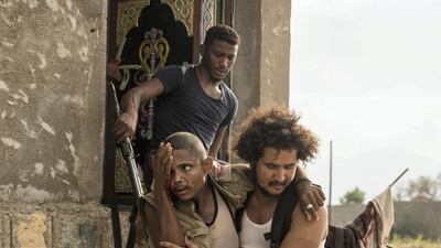 Members of the Tihama forces help a comrade who was injured during clashes with Houthi fighters in Hudayda. June 2, 2018. Asmaa Waguih for The National