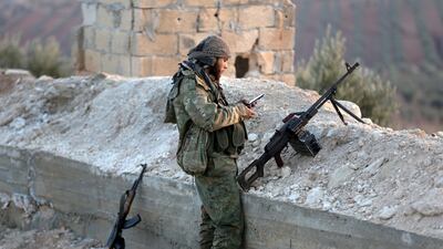A Turkish-backed Free Syrian Army fighter checks his mobile phone in Eastern Afrin yesterday. Khalil Ashawi / Reuters