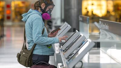 A traveller wearing a respirator uses an automated check-in kiosk at San Francisco International Airport in California. The aviation industry’s losses for this year and next will be five times those accumulated during the 2008-2009 recession, said Iata. Bloomberg