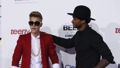 Justin Bieber, in red tailoring, and Usher attend the premiere of 'Justin Bieber's Believe' in Los Angeles, California, on December 18, 2013. Reuters