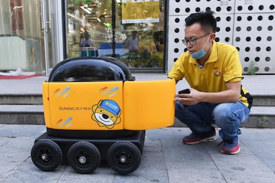 A Suning worker loads a 'little yellow horse' robot. AFP