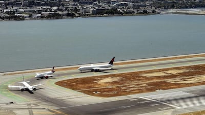 Aircrafts line up next to fields of dead grass at the San Francisco International Airport. Jewel Samad / AFP