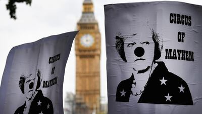epaselect epa06060070 People hold placards with british Prime Minister Theresa May dressed as a clown and sign reading 'Circus of Mayhem' as they take part in an anti-austerity demonstration outside Parliament in London, Britain, 01 July 2017. Tens of thousands of people took part in a demonstration against British Government and called to end austerity, further cuts and privatisation. EPA/ANDY RAIN