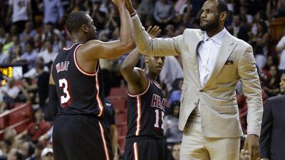 Miami Heat's LeBron James, right, high-fives Dwyane Wade during a time out in the second half of an NBA basketball game against the Chicago Bulls on February 23, 2014, in Miami. The Heat defeated the Bulls 93-79. AP Photo/Lynne Sladky