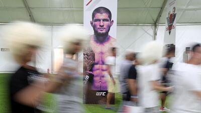UFC fans walk by a poster of Khabib Nurmagomedov. Chris Whiteoak / The National