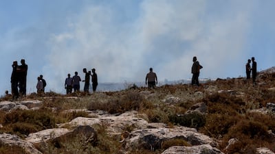 Palestinians watch smoke rising from crowd control grenades thrown by Israeli troops during a protest near Hebron, in the occupied West Bank. Reuters