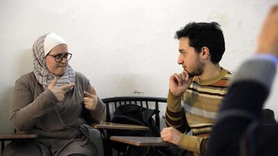 Syrian bio-medical engineer and sign language teacher Wisal Al Ahdab communicates using sign language with 21-year-old deaf student Riyad Hommos during a class at the EEMAA association, an NGO centre for the deaf in Damascus’ Midan district on March 7, 2016. Joseph Eid/AFP