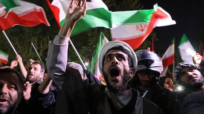 Demonstrators wave Iran's flag and Palestinian flags as they gather in front of the British Embassy in Tehran on Sunday. AFP
