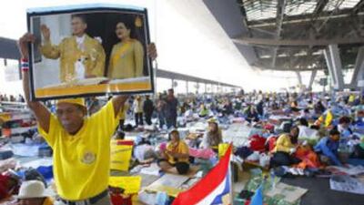 A People's Alliance for Democracy protester holds a portrait of Thai king and queen during a rally at the besieged Suvarnabhumi international airport in Bangkok on Dec 1 2008.