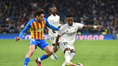 Vinicius Junior of Real Madrid controls the ball under pressure from Fran Perez of Valencia. Getty Images