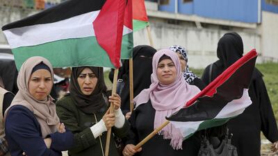 Women wave their national flags during a rally marking the 41st anniversary of Land Day, on the Palestinian side of the Beit Hanoun border crossing between Israel and the Gaza Strip. Adel Hana / AP Photo