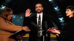 Zohran Mamdani places his hand on the People's Quran, top, and one belonging to his grandfather as he is sworn in as mayor of New York, flanked by attorney general Letitia James, left, and his wife Rama Duwaji. AFP