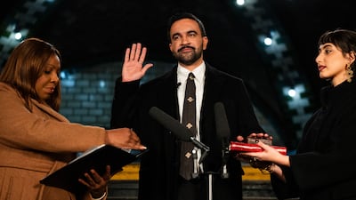 Zohran Mamdani places his hand on the People's Quran, top, and one belonging to his grandfather as he is sworn in as mayor of New York, flanked by attorney general Letitia James, left, and his wife Rama Duwaji. AFP
