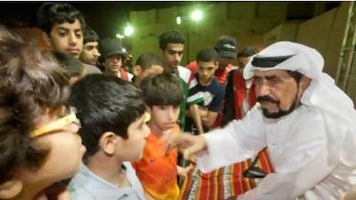 Obaid bin Sandal (right) explains the rules of the game to kids from the Sharjah Youth Centre during the seventh Traditional Handicraft Forum. Jaime Puebla / The National