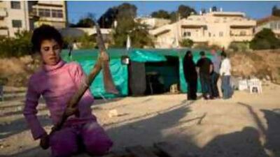 A girl from the Khurd family from East Jerusalem chops wood outside a newly erected tent for them in the city.