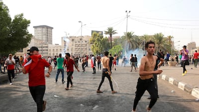 Iraqi protesters run for cover amid tear gas fired by policemen during a demonstration at Tahrir Square, central Baghdad. EPA