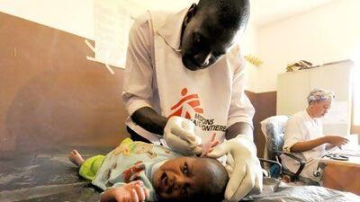 A worker from Medecins Sands Frontieres examines a sick baby in Gao, in the north of Mali. Sia Kambou / AFP