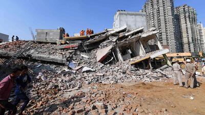 Members of the National Disaster Response Force, along with local police, search for victims after an under construction building collapsed in the village of Shah Beri village in Greater Noida, a satellite town east of the Indian capital, in Uttar Pradesh. AFP
