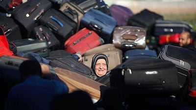 A Palestinian passenger, hoping to cross into Egypt, searches for her bag as she waits at the Rafah crossing, between Egypt and the southern Gaza Strip. Ibraheem Abu Mustafa / Reuters