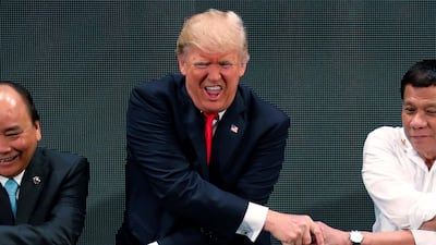 US president Donald Trump smiles with other leaders for the traditional 'ASEAN handshake' in Manila, Philippines. Jonathan Ernst / Reuters