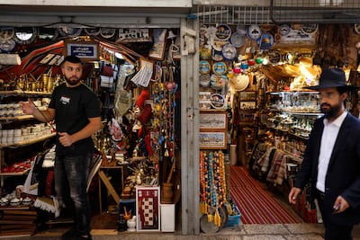 An Israeli Orthodox Jew man walks past a Palestinian souvenir shop in the Old City of Jerusalem on August 28, 2025. AFP