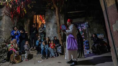 An Egyptian 'musaharati' beats a drum and makes calls for observant Muslims to wake up for the suhoor meal in the old quarter of Cairo during Ramadan. AFP