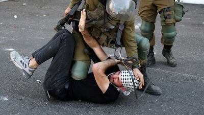 Israeli soldiers arrest a Palestinian man during clashes that broke out during a protest in the West Bank city of Hebron. EPA