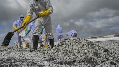 Sri Lankan Navy soldiers remove debris washed ashore from the Singapore-registered container ship 'MV X-Press Pearl', which is still burning, a ninth consecutive day, off Colombo harbour in Sri Lanka. AFP