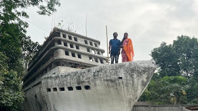 Mintu and Iti Roy stand proudly on the bow of their boat-shaped home. Photo: Anurag Khat