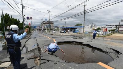 Police check a collapsed road following an earthquake in Takatsuki, north of Osaka prefecture. AFP