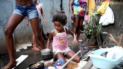 Jessica washes dishes at the one pipe with running water available to dozens of area residents. (Mario Tama / Getty Images / March 30, 2014)