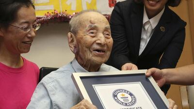 Yasutaro Koide, 112, receives the Guinness World Records certificate as he is formally recognised as the world's oldest man at a nursing home in Nagoya, central Japan, on August 21. Koji Sasahara/AP