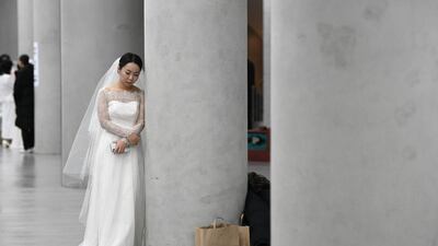 A bride leans on a pillar before a mass wedding ceremony organised by the Unification Church at Cheongshim Peace World Center in Gapyeong. AFP