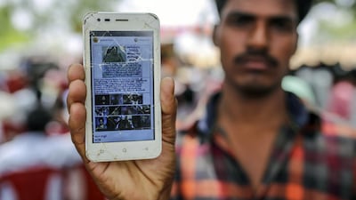 An attendee holds a mobile phone displaying a fake message shared on WhatsApp at an event to raise awareness on fake news in Balgera village in Telangana, India. Dhiraj Singh / Bloomberg