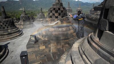 A worker cleans volcanic ash off the stupas at the Borobudur temple in Magelang Regency, a day after Mount Merapi erupted in Sleman, Indonesia. AFP
