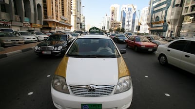 An old gold and white Abu Dhabi taxi. Andrew Parsons / The National