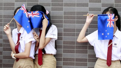 Vietnamese students cover their faces with New Zealand’s flags on November 16, 2015, while they wait for the arrival of prime minister John Key at Vin School in Hanoi, Vietnam. Kham / Reuters