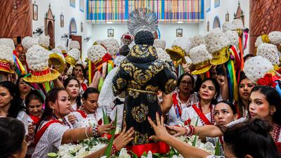Women touch the image of Saint Benedict as they take part in the nine-day Marujada religious festival in Braganca, Para state, Brazil. AFP