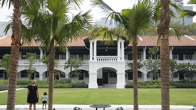 Guests stand in the Palm Court at the Raffles Hotel. Bloomberg